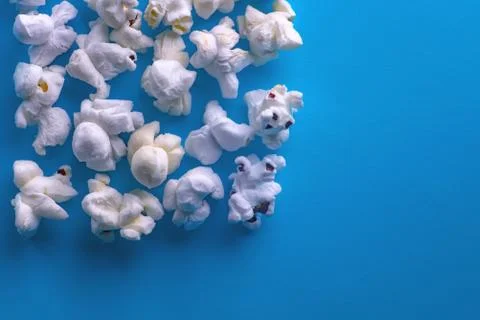 Popcorn on a blue background. Macro image of popcorn. Place for your text Stock Photos