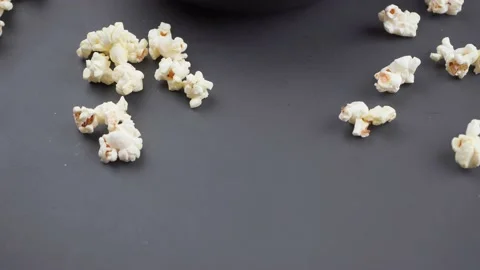Popcorn in a bowl on a black table, camera movement from the bottom up. Stock Footage 155450116