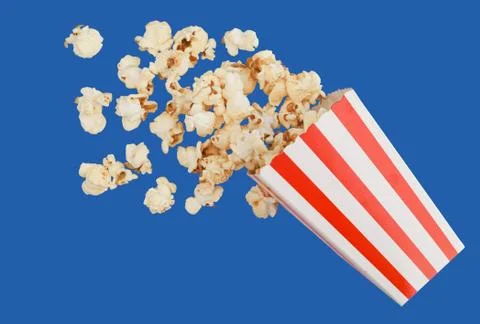Popcorn in classic box, red and white splashing out of the box, blue backgrou Stock Photos