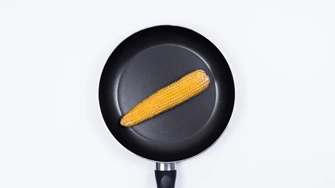 Popcorn is cooked in a white kitchen in a frying pan. Corn. 4k. Stop Motion. Video stock 87166390