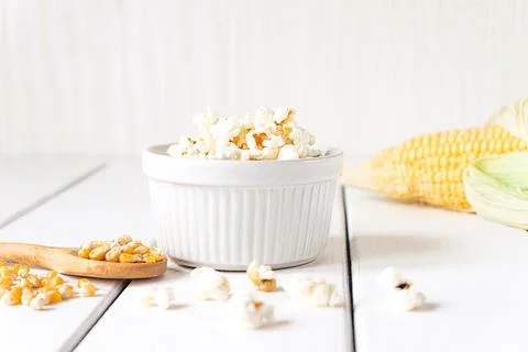 Popcorn, corn cob and corn grains on white tabletop Stock Photos