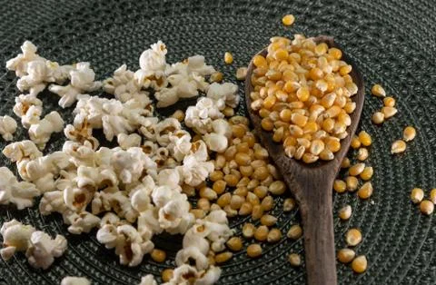 Popcorn corn grains on a kitchen table and household items Stock Photos