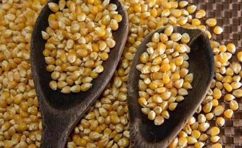 Popcorn corn grains on a kitchen table and household items Stock Photos