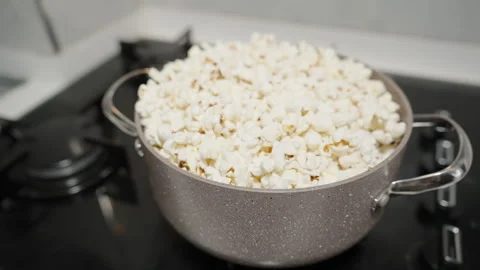 Popcorn explodes at the bottom of the pot and tosses up the already popped kerne Stock Footage 270386298