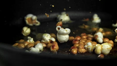 Popcorn explodes in the pan. Filmed on a high-speed camera at 1000 fps. Stock Footage 308462823