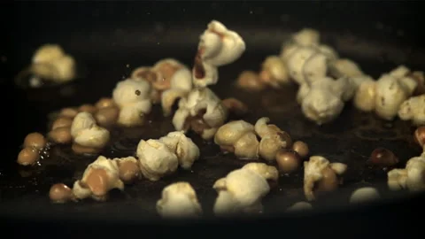 Popcorn explodes in the pan. Filmed on a high-speed camera at 1000 fps. Stock Footage 308472592