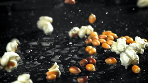 Popcorn explodes in a pan with a splash of oil. Filmed on a high-speed camera at Stock Footage 263268998