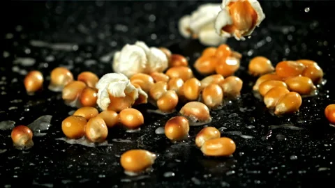 Popcorn explodes in a pan with a splash of oil. Filmed on a high-speed camera at Stock Footage 263278566
