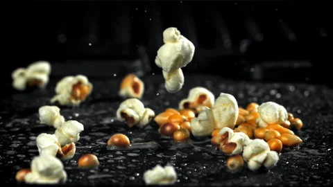 Popcorn explodes in a pan with a splash of oil. Filmed on a high-speed camera at Stock Footage 263373740