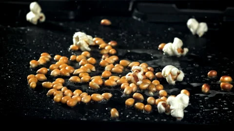 Popcorn explodes in a pan with a splash of oil. Filmed on a high-speed camera at Stock Footage 263393863