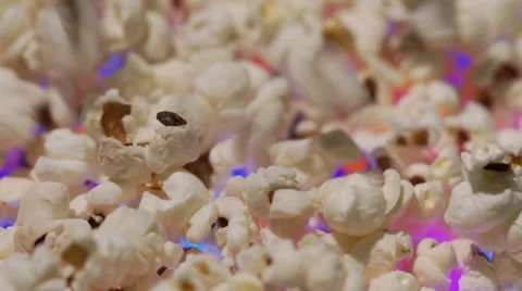 Popcorn falling down one-by-one on colorful background Stock Footage 67675076