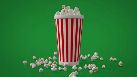 Popcorn falling down into striped paper cup for cinema film watching 스톡 동영상 73575793