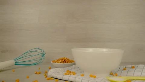 Popcorn falling down into White Bowl with ingredient yellow corns and salt  動画素材 107510977