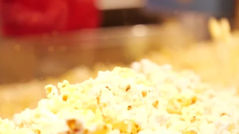 Popcorn falling over the edge of a pot or machine Stock Footage 166663998