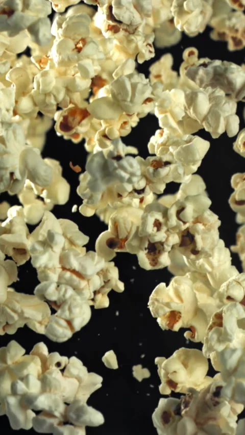 Popcorn flies up and falls down. On a black background. Filmed on a high-speed Stock Footage 335357730