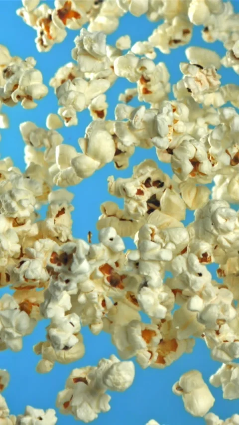 Popcorn flies up and falls down. On a blue background. Filmed on a high-speed Stock Footage 335357780