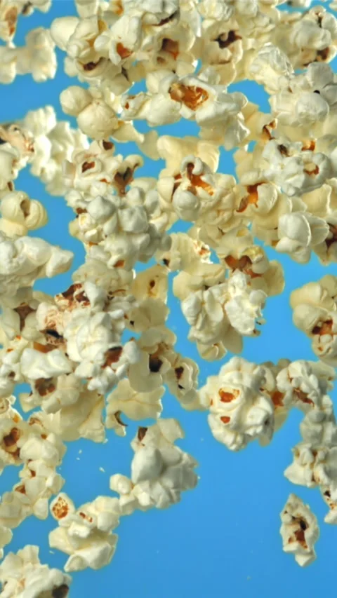 Popcorn flies up and falls down. On a blue background. Filmed on a high-speed Stock Footage 335357857