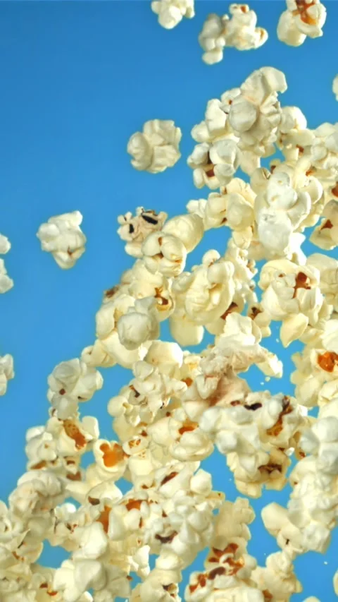 Popcorn flies up and falls down. On a blue background. Filmed on a high-speed Stock Footage 335357931