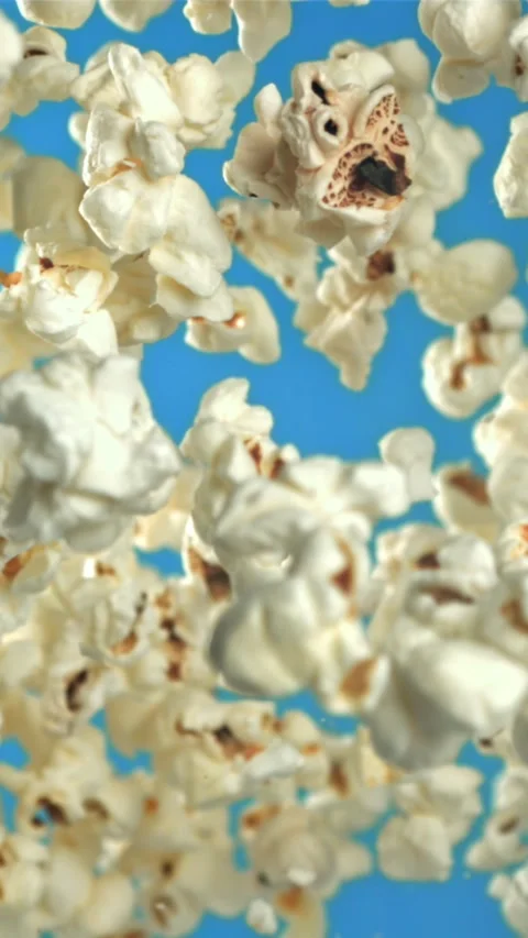Popcorn flies up and falls down. On a blue background. Filmed on a high-speed Stock Footage 335359172