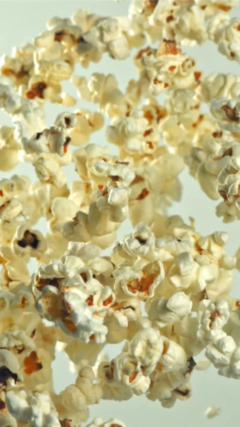 Popcorn flies up and falls down. On a light background. Filmed on a high-speed Stock Footage 335359530