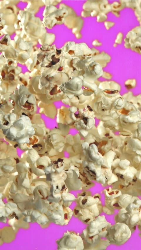 Popcorn flies up and falls down. On a purple background. Filmed on a high-speed Stock Footage 335359603
