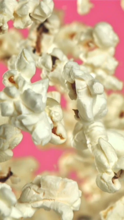 Popcorn flies up and falls down. On a pink background. Filmed on a high-speed Stock Footage 335359739