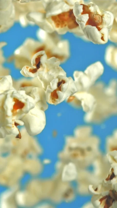 Popcorn flies up and falls down. On a blue background. Filmed on a high-speed Stock Footage 335359858