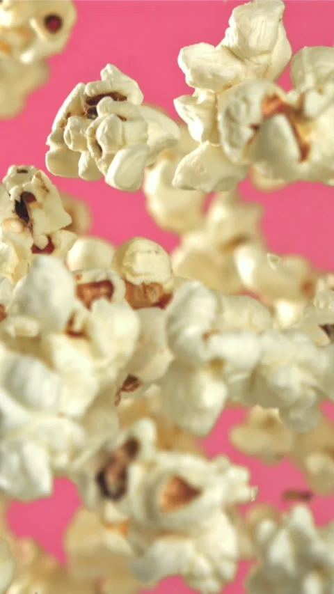 Popcorn flies up and falls down. On a pink background. Filmed on a high-speed Stock Footage 335360070
