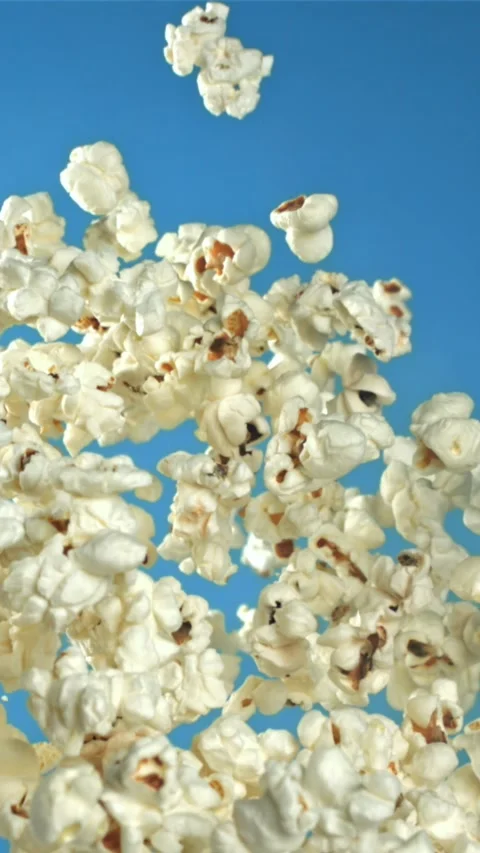 Popcorn flies up and falls down. On a blue background. Filmed on a high-speed Stock Footage 335360930