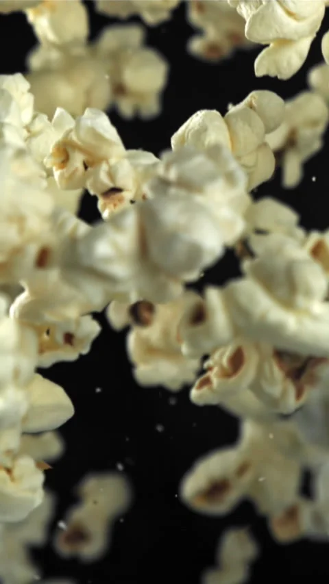 Popcorn flies up and falls down. On a black background. Filmed on a high-speed Stock Footage 335361708