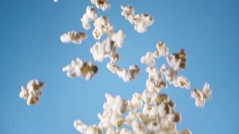 Popcorn flying on blue background Stock Footage 130876358
