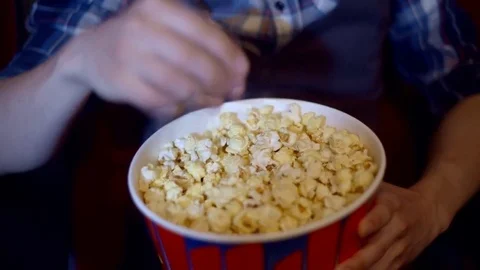 Popcorn forever. Closeup cropped shot of a happy smiling woman grabbing popcorn Video stock 75037352
