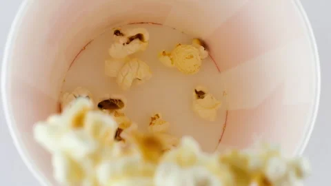 Popcorn grains falling into red and white striped bucket Stock Footage 281094642