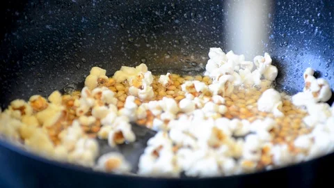 Popcorn in hot oil in a Teflon pan close-up Stock Footage 106197316