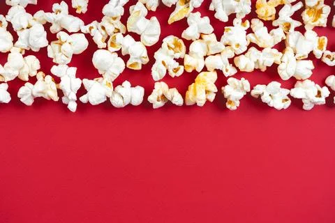 Popcorn pattern, border on red background. Top view, flat lay with copy space Stock Photos