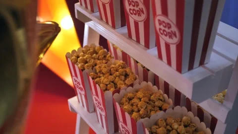Popcorn in a red striped paper cup on a wooden stand Stock Footage 277074794