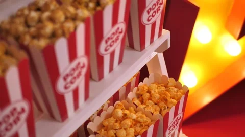 Popcorn in a red striped paper cup on a wooden stand Stock Footage 277074809