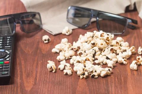 Popcorn, remote control and 3D glasses Stock Photos