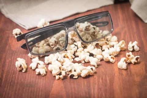 Popcorn, remote control and 3D glasses Stock Photos