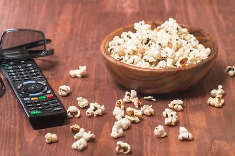 Popcorn, remote control and 3D glasses Stock Photos
