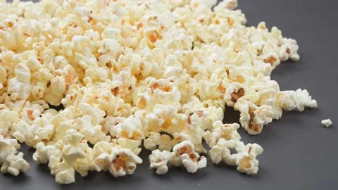 Popcorn rotates on a gray table Stock Footage 157976556
