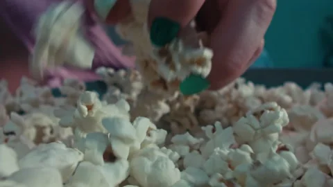 Popcorn Snack Being Grabbed by a Hand from a Bowl During a Movie Night Vidéo 331099098