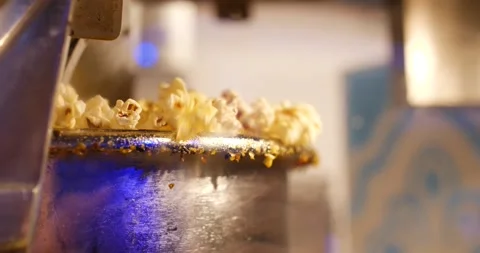 Popcorn spilling over the edge of a pot or machine slow motion Stock Footage 166663881