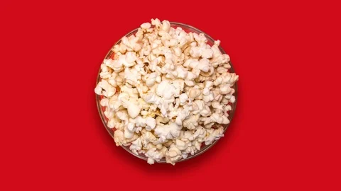 Popcorn in a transparent plate on a red background Video stock 122303088