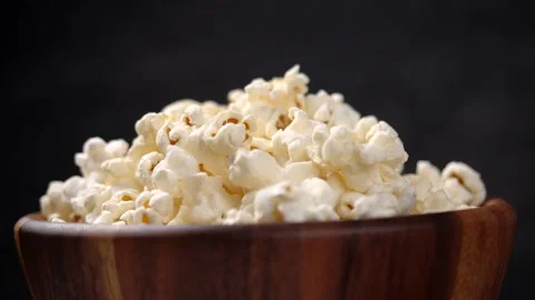 Popcorn turning in slow motion, Close-up of popcorn in wooden bowl Stock Footage 143843367