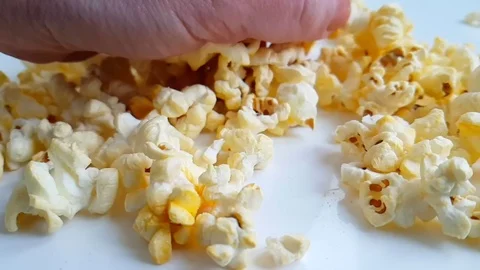 Popcorn on white background drops, slow-motion shooting hand Stock Footage