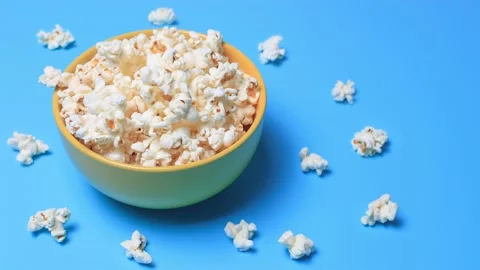 Popcorn in a yellow cup on a turquoise background. Stock Footage 131319942