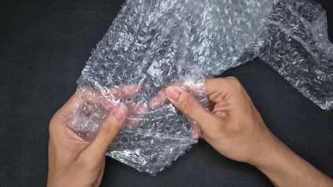 Popping the bubbles in bubble wrap Stock Footage 292974197