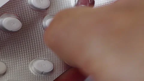 Popping pills from a blister pack. Stock Footage 337373323