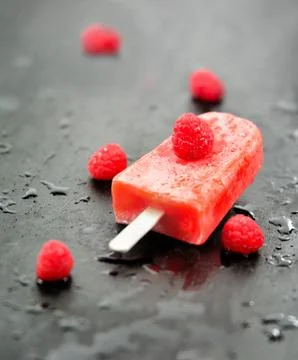 Popsicle raspberry fruit on the table black wood Stock Photos